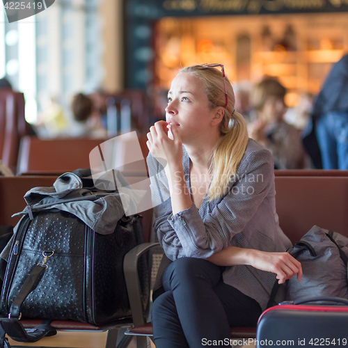 Image of Woman waiting on airport terminal.