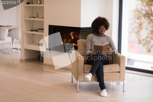 Image of black woman at home reading book