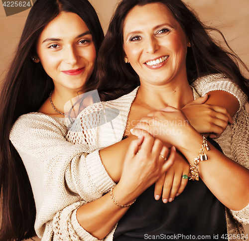 Image of cute pretty teen daughter with mature mother hugging, fashion st