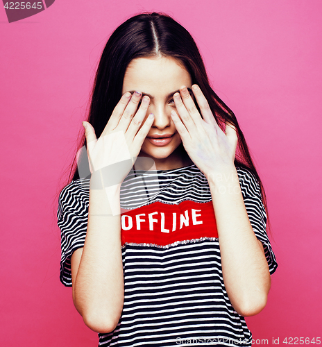 Image of young pretty teenage woman emotional posing on pink background, fashion lifestyle people concept 