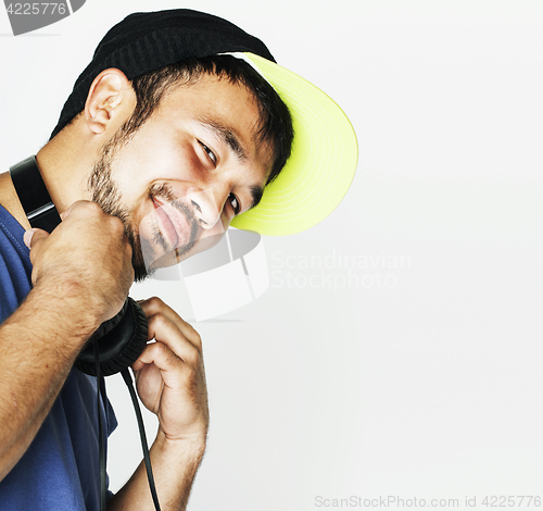 Image of young asian man in hat and headphones listening music on white b