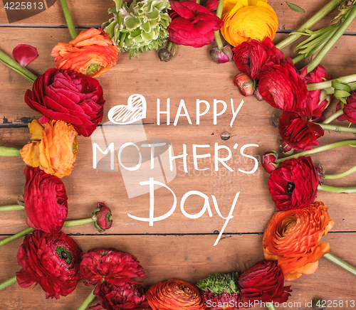 Image of Ranunkulyus bouquet of red flowers on a wooden background