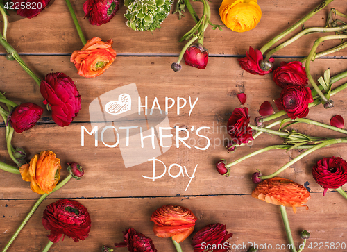 Image of Ranunkulyus bouquet of red flowers on a wooden background