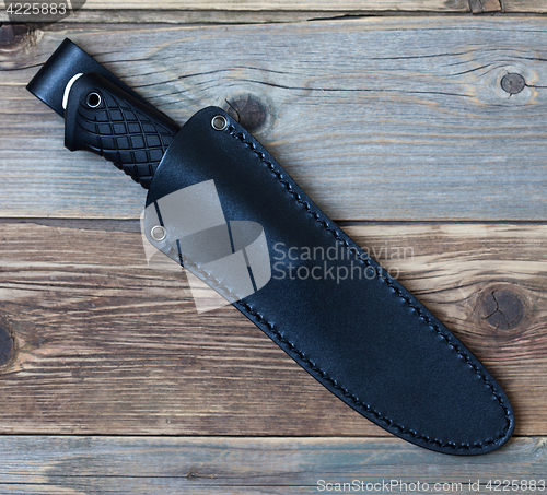 Image of steel hunting knife in leather sheath