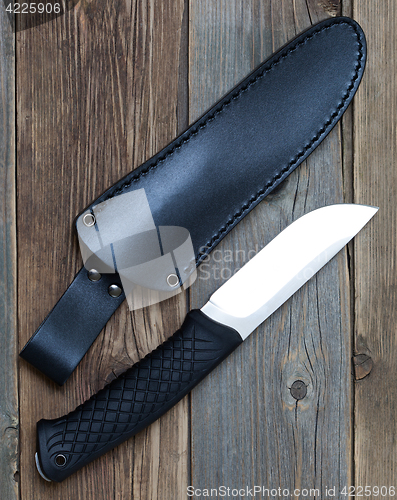 Image of steel hunting knife near the leather sheath