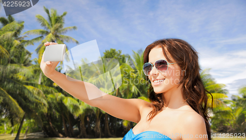 Image of woman in swimsuit taking selfie with smatphone