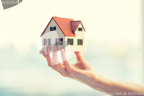 Image of close up of hands holding house or home model