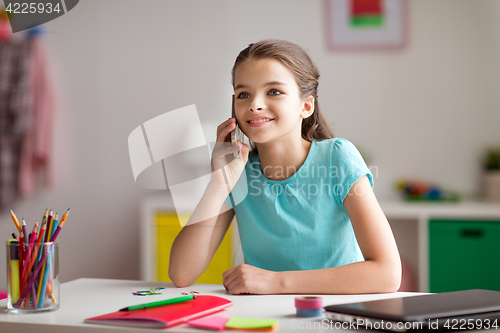 Image of happy girl calling on smartphone at home