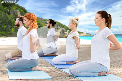 Image of people making yoga in hero pose outdoors