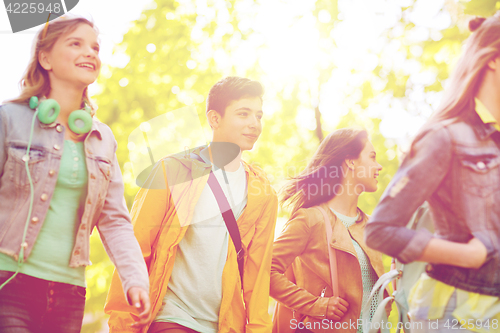 Image of group of happy teenage students walking outdoors