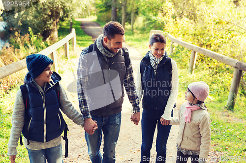 Image of happy family with backpacks hiking in woods