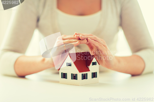 Image of close up of hands protecting house or home model