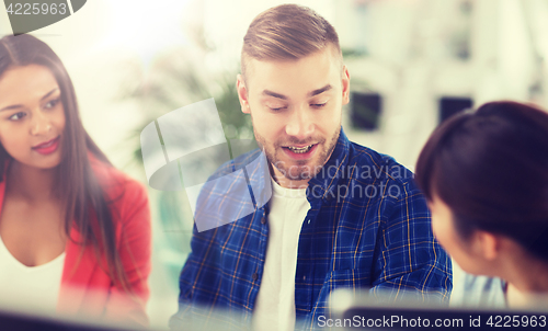 Image of happy creative team or students working at office