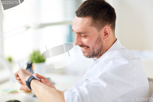 Image of close up of businessman with smartwatch at office