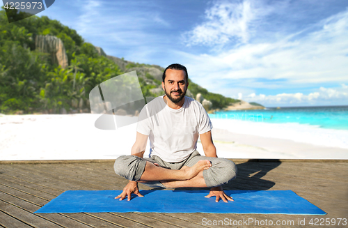 Image of man making yoga in scale pose outdoors