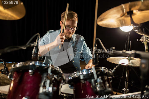 Image of male musician playing drums and cymbals at concert