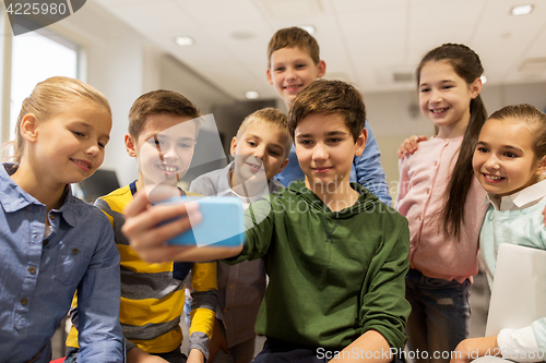 Image of group of school kids taking selfie with smartphone