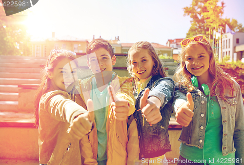 Image of happy students or friends showing thumbs up