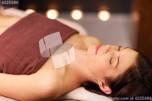 Image of happy young woman lying at spa or massage parlor