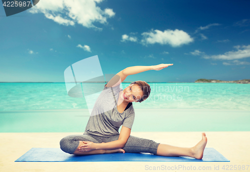 Image of happy woman making yoga and stretching on mat