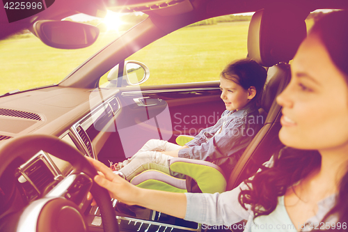 Image of happy woman with little girl driving in car