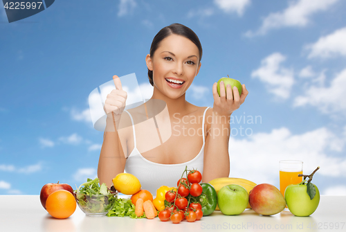 Image of woman with fruits and vegetables showing thumbs up