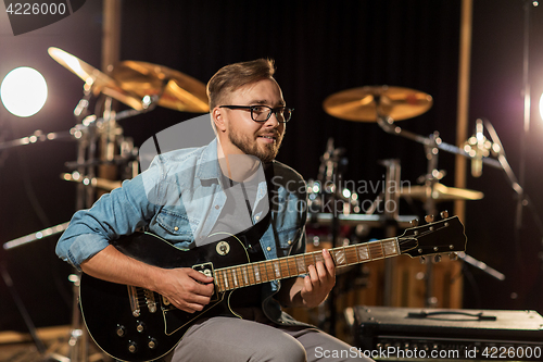 Image of man playing guitar at studio rehearsal