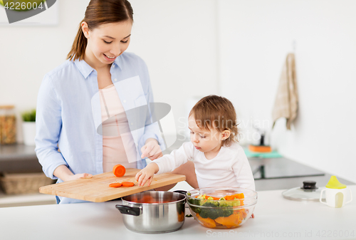 Image of happy mother and baby cooking food at home kitchen