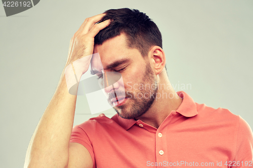 Image of unhappy man suffering from head ache