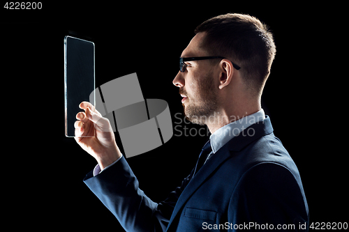 Image of businessman in suit working with transparent tablet pc