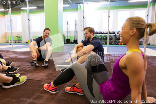 Image of group of happy friends resting in gym