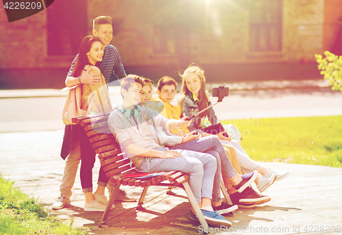 Image of happy teenage students taking selfie by smartphone