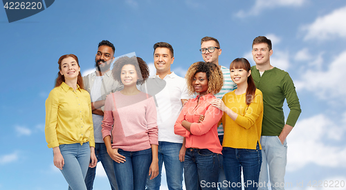 Image of international group of happy people over blue sky