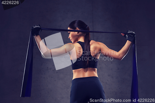 Image of woman with expander exercising in gym