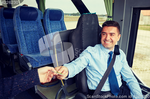 Image of bus driver taking ticket or card from passenger