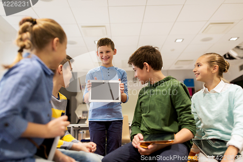 Image of group of happy children with tablet pc at school