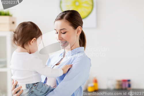 Image of happy mother and little baby girl at home kitchen