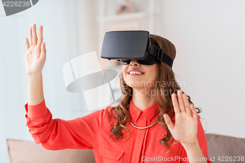 Image of happy woman in virtual reality headset at home