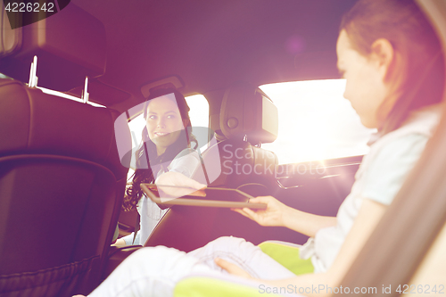 Image of happy family with tablet pc driving in car