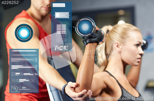 Image of man and woman with dumbbells in gym