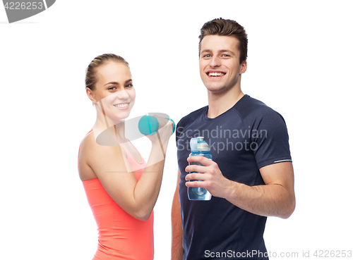 Image of sportive man and woman with dumbbell and water