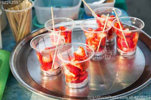 Image of strawberry in plastic cups at street market