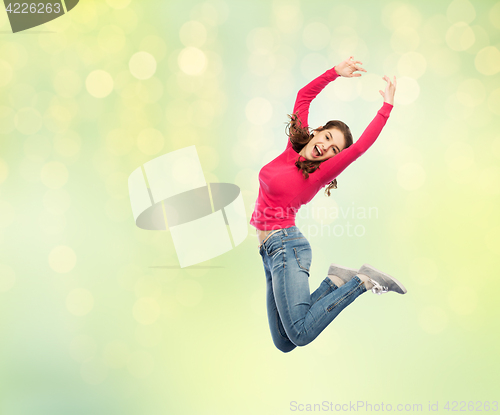 Image of happy young woman jumping in air or dancing