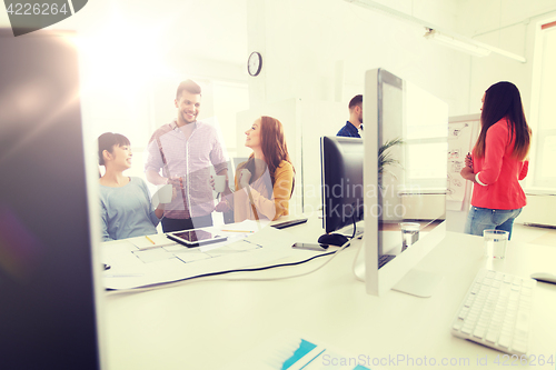 Image of happy creative team rinking coffee at office