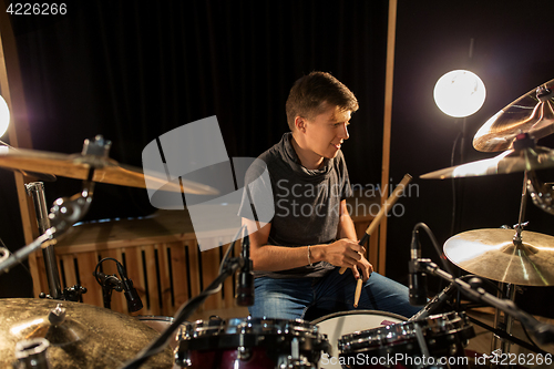 Image of male musician playing drums and cymbals at concert