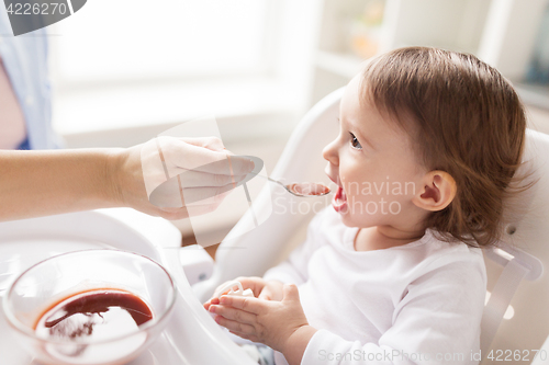 Image of mother feeding baby with puree at home