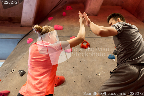 Image of man and woman exercising at indoor climbing gym