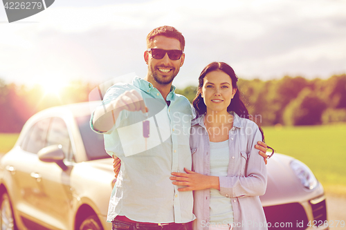 Image of happy man and woman with car key hugging 