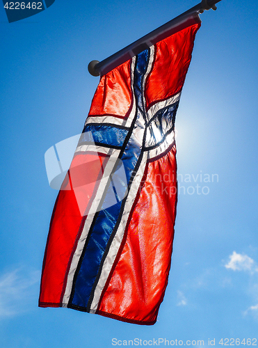 Image of Norwegian flag up close, towards the sun on beautiful blue sky