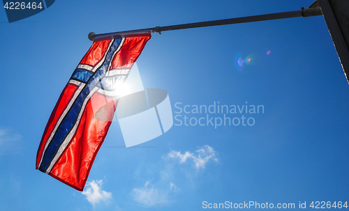 Image of Norwegian flag up close, towards the sun on beautiful blue sky